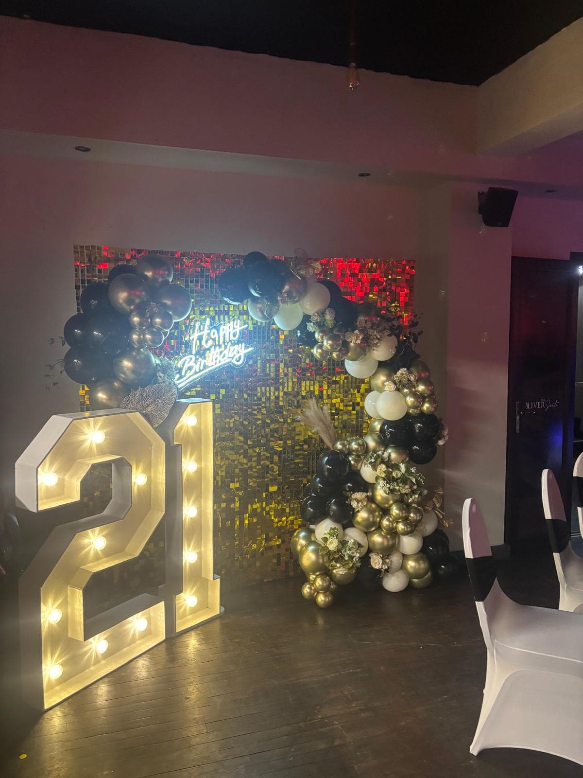 Light-up 21 letters against a gold sequin wall at a birthday at Gracy's
