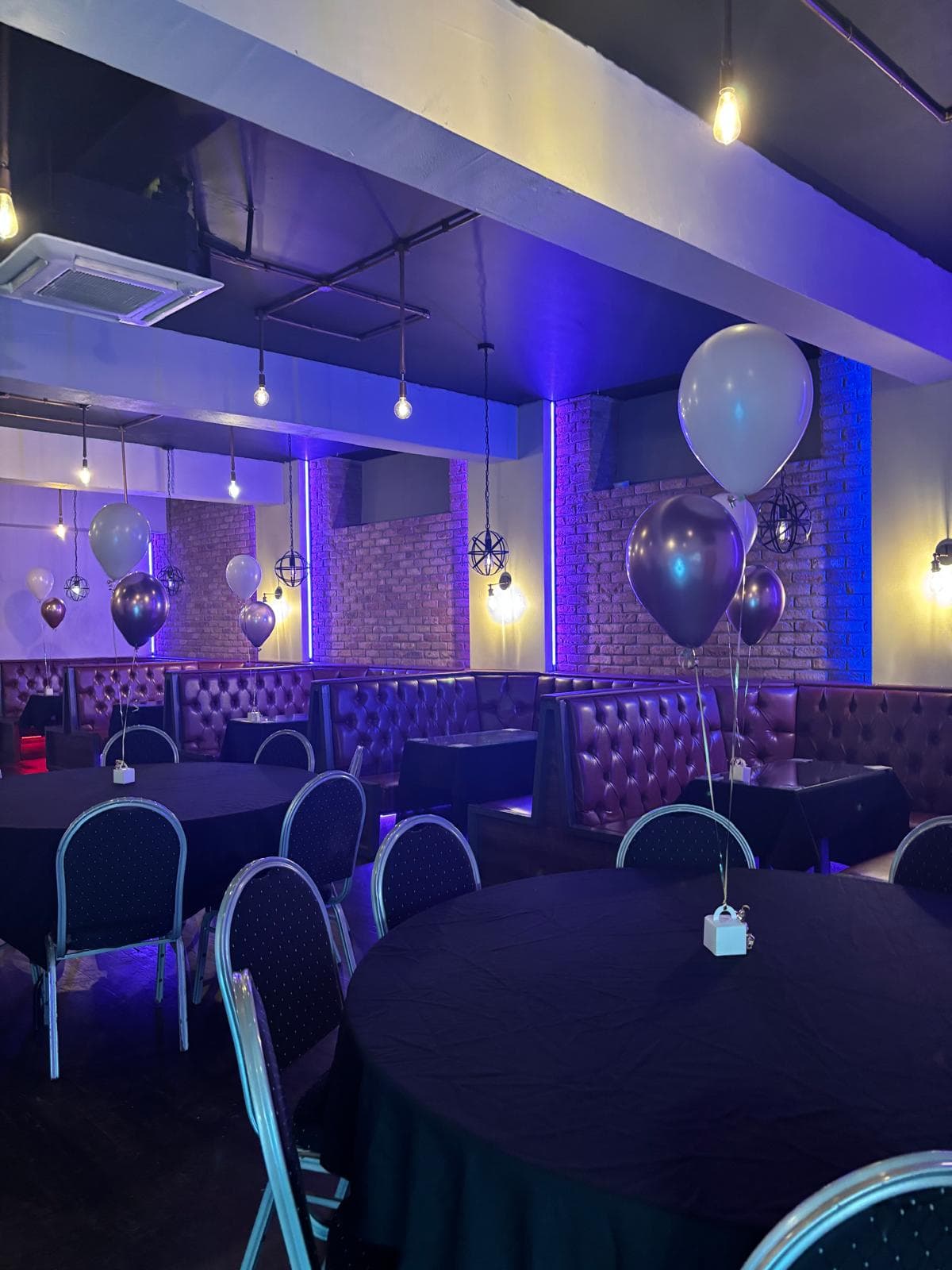A slow sweep of the empty function space at Gracy's, booths and brick in warm light
